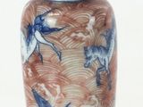 a small blue and white vase with birds on it