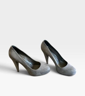 une paire de chaussures à talons hauts pour femme posée sur une surface blanche