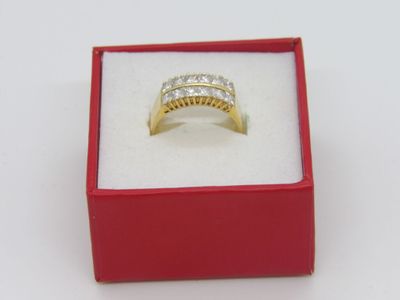 bague en or jaune sertie de diamants, présentée dans un coffret rouge posé sur un fond blanc