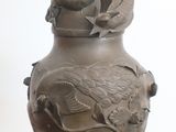 un vase orné d'un dragon, posé sur une table
