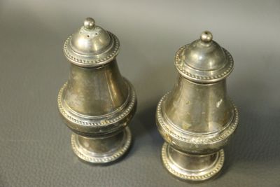 two silver salt and pepper shakers sitting on a table