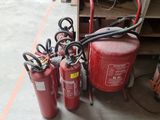 several fire extinguisors are lined up next to a pallet