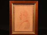 portrait d'une femme de profil dans un cadre en bois sur fond noir