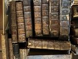 many old books stacked on top of each other in a box