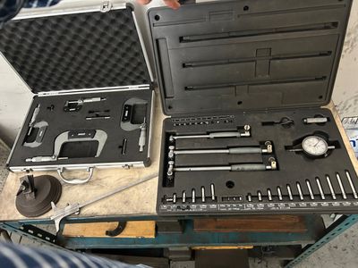 un homme qui tient un coffret à outils posé sur une table