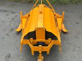 a close up of a yellow machine on the ground near a stone wall