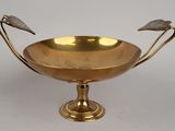 a gold bowl with two birds on it