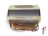 an old accordion with writing on it sitting on a white surface