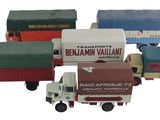 plusieurs camions jouets sont alignés sur une surface blanche