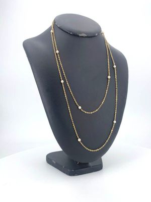 a close up of a necklace on a mannequin with a white background