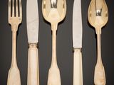 four forks and a knife on a table with a black background