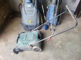 a lawn mower that is sitting on the floor next to a vacuum