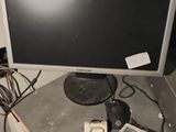a desk with a computer monitor and other electronics on it