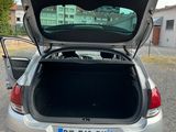 a silver car with its trunk open in a parking lot