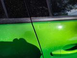 a green car that has a green door handle on it