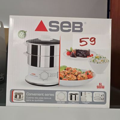 quelqu'un tient une boîte de nourriture devant un micro-ondes