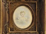 une vieille photo représentant une jeune fille en robe blanche, dans un cadre doré