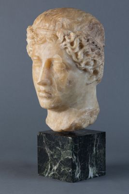 tête de femme en marbre aux cheveux bouclés, posée sur un socle en marbre