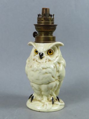 une figurine représentant un hibou blanc posée sur une table