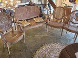 several chairs and a couch in a room with a chandelier in the background