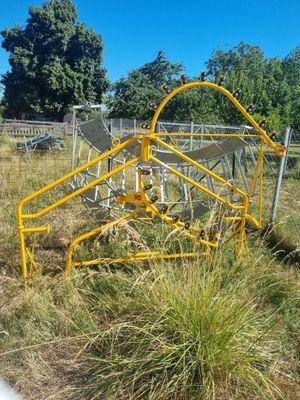 une structure métallique jaune au milieu d'un champ herbeux