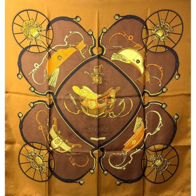 foulard en soie marron orné d'un motif doré et noir représentant des oiseaux et des vélos