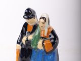 two figurines of a man and a woman standing next to each other