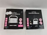 two boxes of white and black electronic gadgets on a white surface