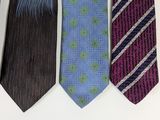 three different colored ties hanging on a wall next to each other