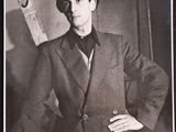 black and white photograph of a man in a suit and tie holding a pair of skis