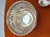 un bol en argent et une cuillère en argent posés sur une table