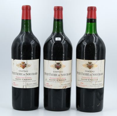 three bottles of red wine sitting next to each other on a white surface