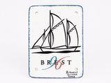 white and blue ceramic plaque with a picture of a sailboat on it