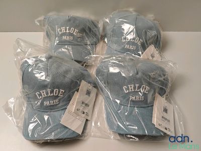 quatre chapeaux sont emballés dans des sacs en plastique sur une table