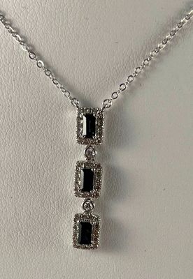 une photo d'un collier de diamants noir et blanc porté par un mannequin