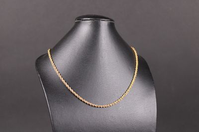 un collier à chaîne en or sur un présentoir à mannequin