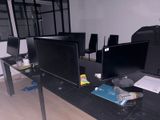 trois écrans d'ordinateur posés sur un bureau dans une pièce