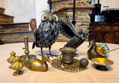 an owl statue sitting on top of a table next to other items
