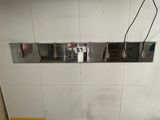 un urinoir situé dans un coin des toilettes, sur lequel est accrochée une pancarte