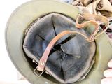 a person holding a helmet with a leather strap