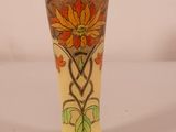 a yellow vase with a floral design on it