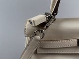 the handle of a white handbag with a metal clasp