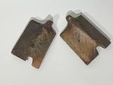 two pieces of metal are sitting on a white surface