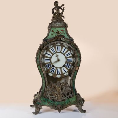 a green clock with roman numerals on the face