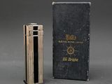 un vieux livre et un briquet posés l'un à côté de l'autre sur une table
