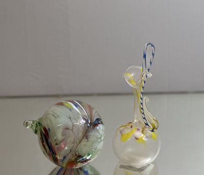 two glass figurines sitting on a glass table