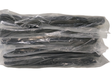 de nombreux bâtonnets noirs emballés dans du plastique, posés sur une surface blanche