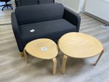 un canapé noir et deux tables en bois dans un salon