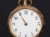 a close up of a gold pocket watch on a black surface