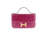 un sac à main rose avec un « H » doré sur la poignée